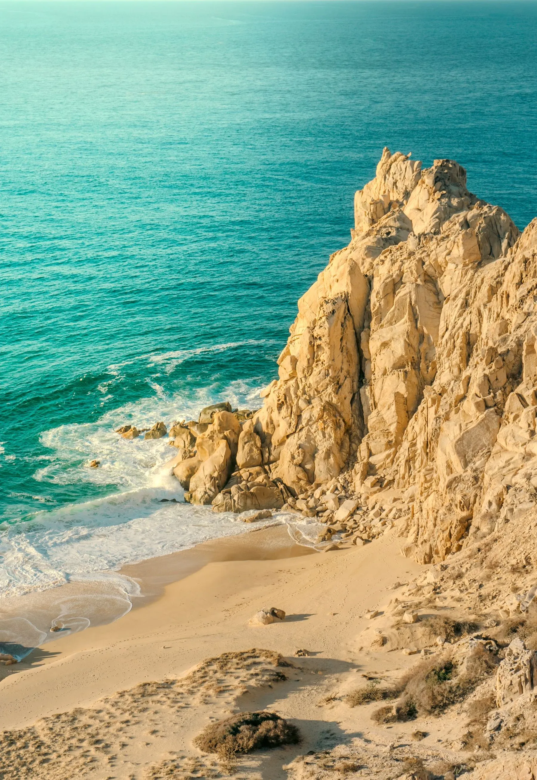 Cabo beach, rocky cliffs and ocean, photographed by Jules Clark